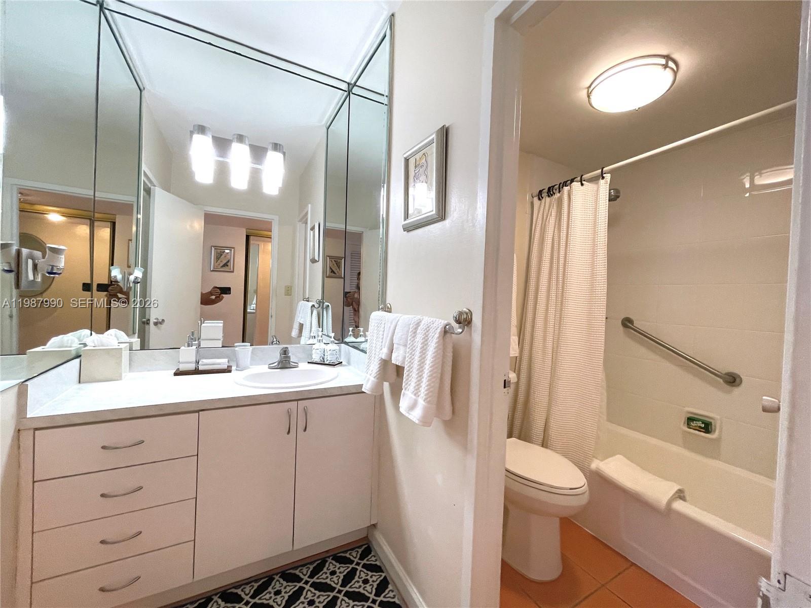 A bathroom features a white vanity, a large mirror, and a shower-tub combination — 100 Lincoln Rd # 836, Miami Beach FL 33139, MIAMI BEACH, FL