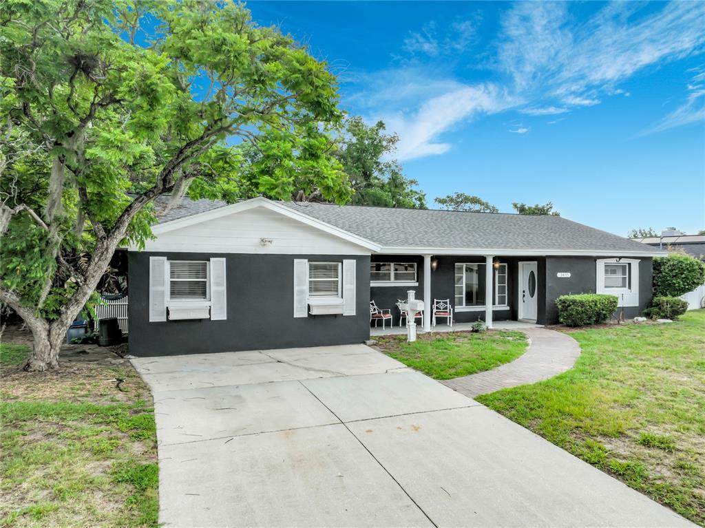 A single-story house with a dark gray exterior, white shutters, and a concrete driveway — 3417 PERSHING AVENUE, ORLANDO, FL