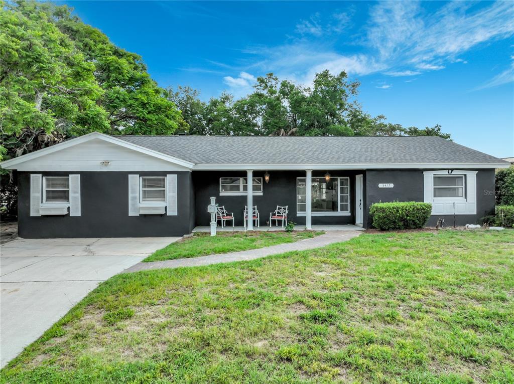 A single-story house with dark gray siding, white trim, and a covered front porch — 3417 PERSHING AVENUE, ORLANDO, FL