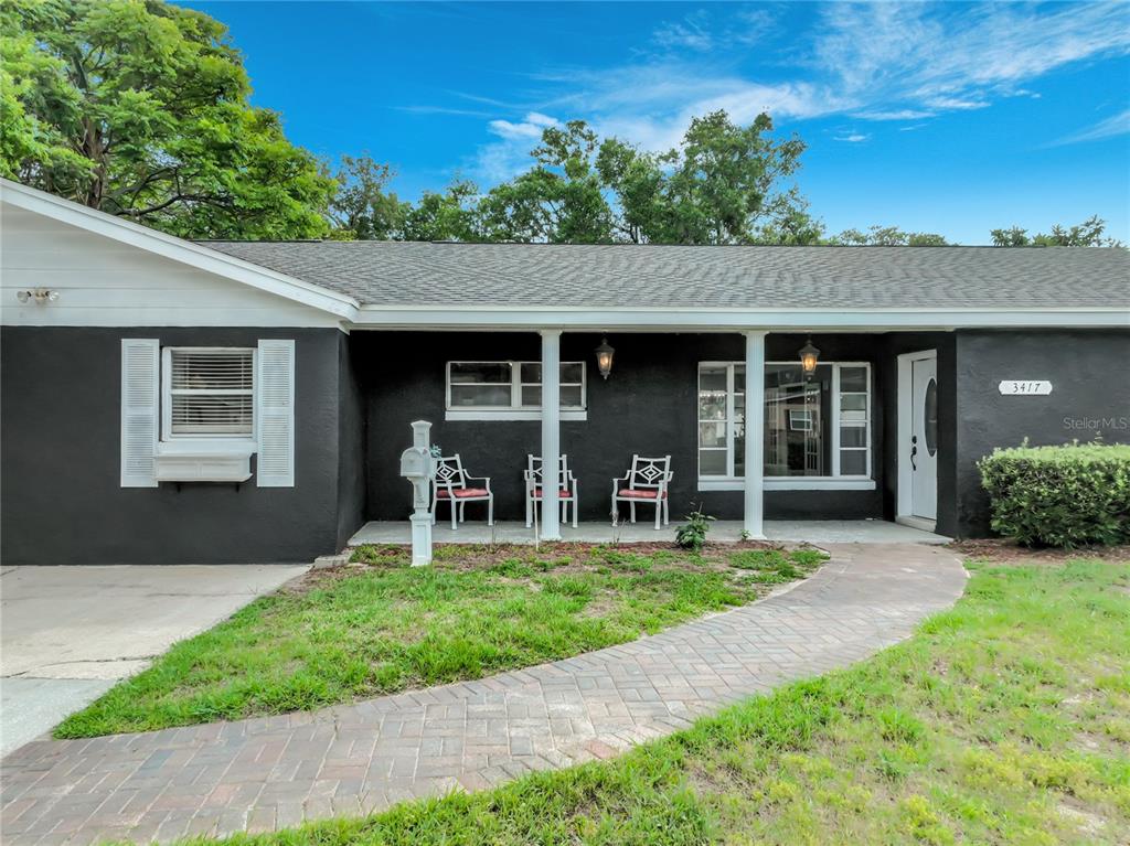 A single-story house with a dark exterior, white trim, and a brick paver walkway — 3417 PERSHING AVENUE, ORLANDO, FL