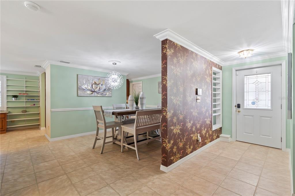 A dining area features a floral accent wall, light green paint, and tile flooring — 12352 83RD AVENUE, SEMINOLE, FL
