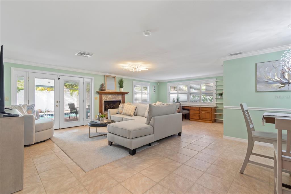 A living room features light tile floors, a sectional sofa, a fireplace, and glass doors — 12352 83RD AVENUE, SEMINOLE, FL