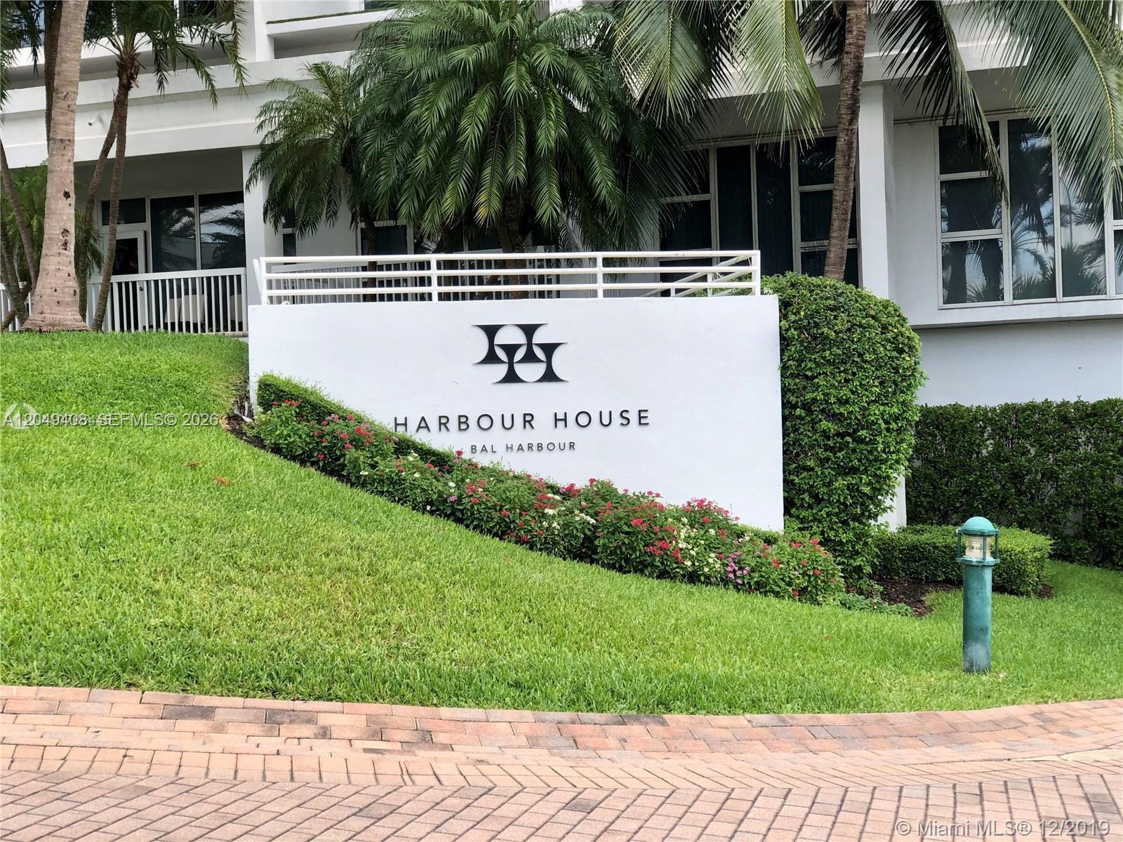 A white sign for Harbour House Bal Harbour sits on a grassy slope with landscaping — 10275 Collins Ave # 230, Bal Harbour FL 33154, BAL HARBOUR, FL