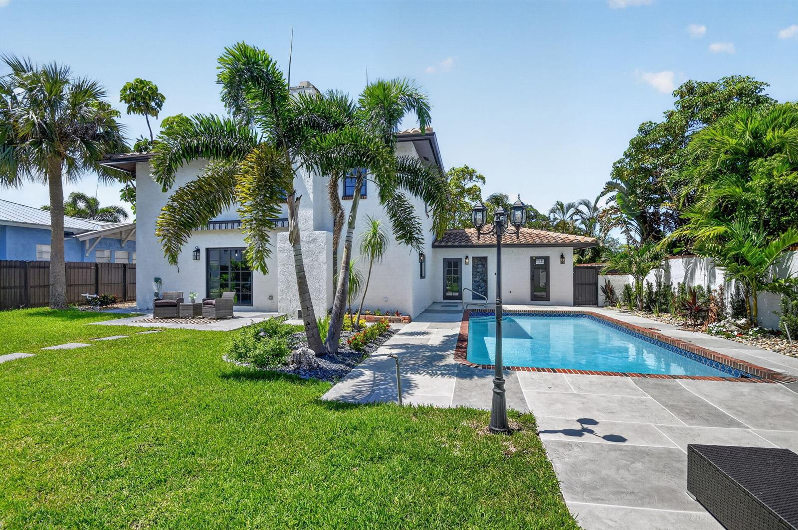 A white two-story house with a backyard pool, palm trees, and a grassy lawn — 308 Greymon Drive, West Palm Beach FL 33405, WEST PALM BEACH, FL