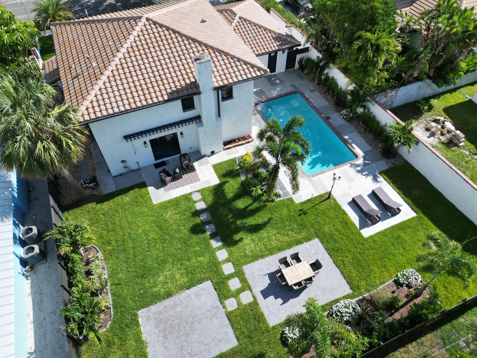 An aerial view of a backyard featuring a swimming pool, patio, and landscaped lawn — 308 Greymon Drive, West Palm Beach FL 33405, WEST PALM BEACH, FL