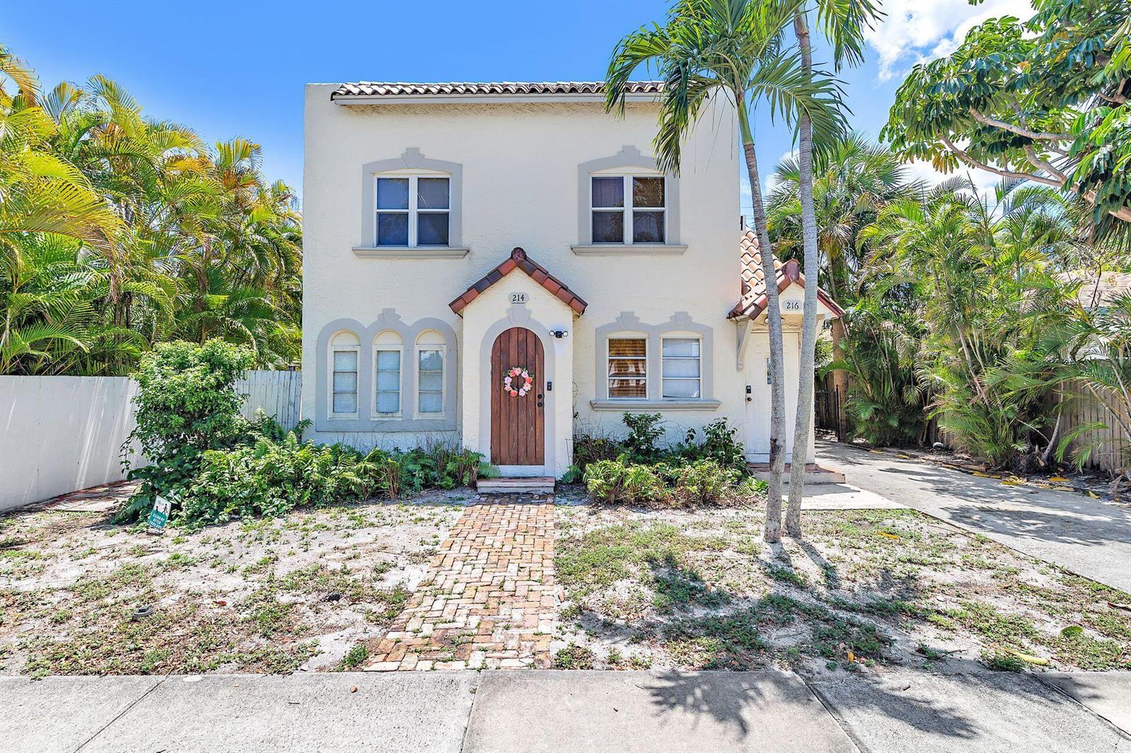A two-story stucco house with a brick walkway and palm trees in the front yard — 214 Conniston Road, West Palm Beach FL 33405, WEST PALM BEACH, FL