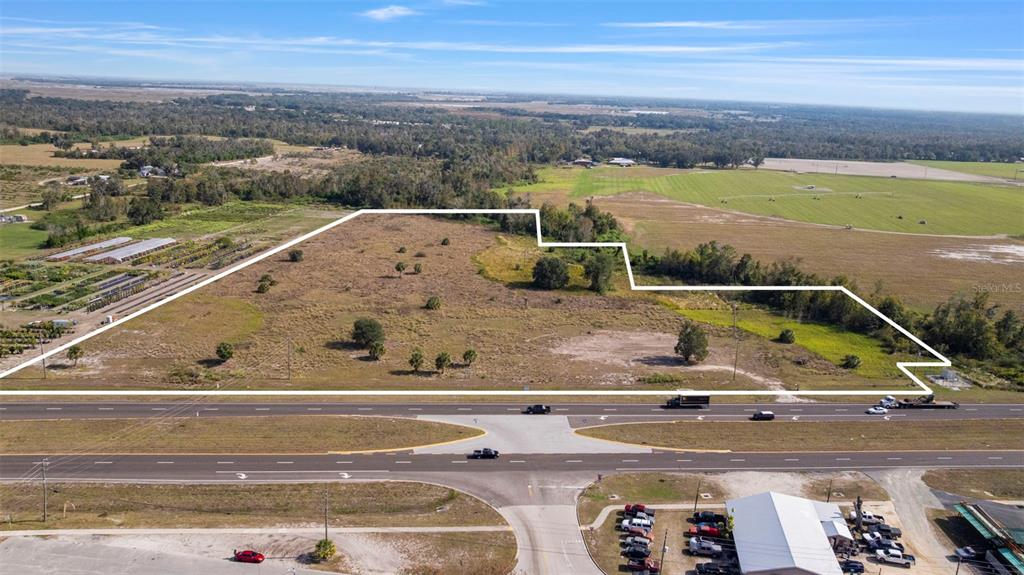 An aerial view shows a large, vacant, irregularly shaped plot of land bordering a highway — 1768 N US HWY 17, WAUCHULA, FL