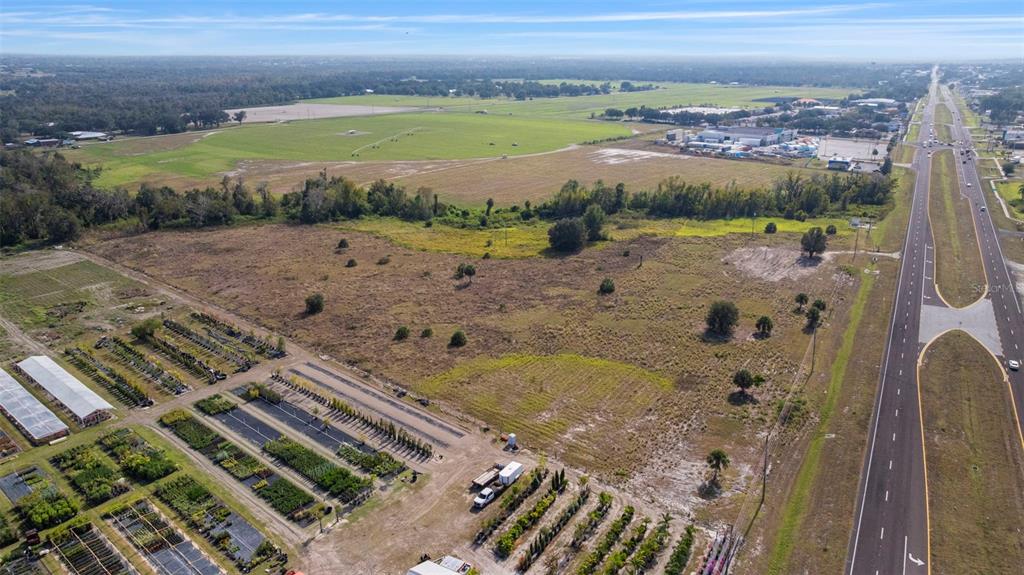 An aerial view shows a large, undeveloped grassy lot adjacent to a plant nursery and highway — 1768 N US HWY 17, WAUCHULA, FL