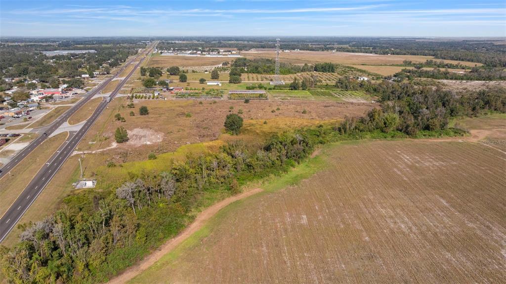 An aerial view shows a large, undeveloped field adjacent to a multi-lane highway — 1768 N US HWY 17, WAUCHULA, FL