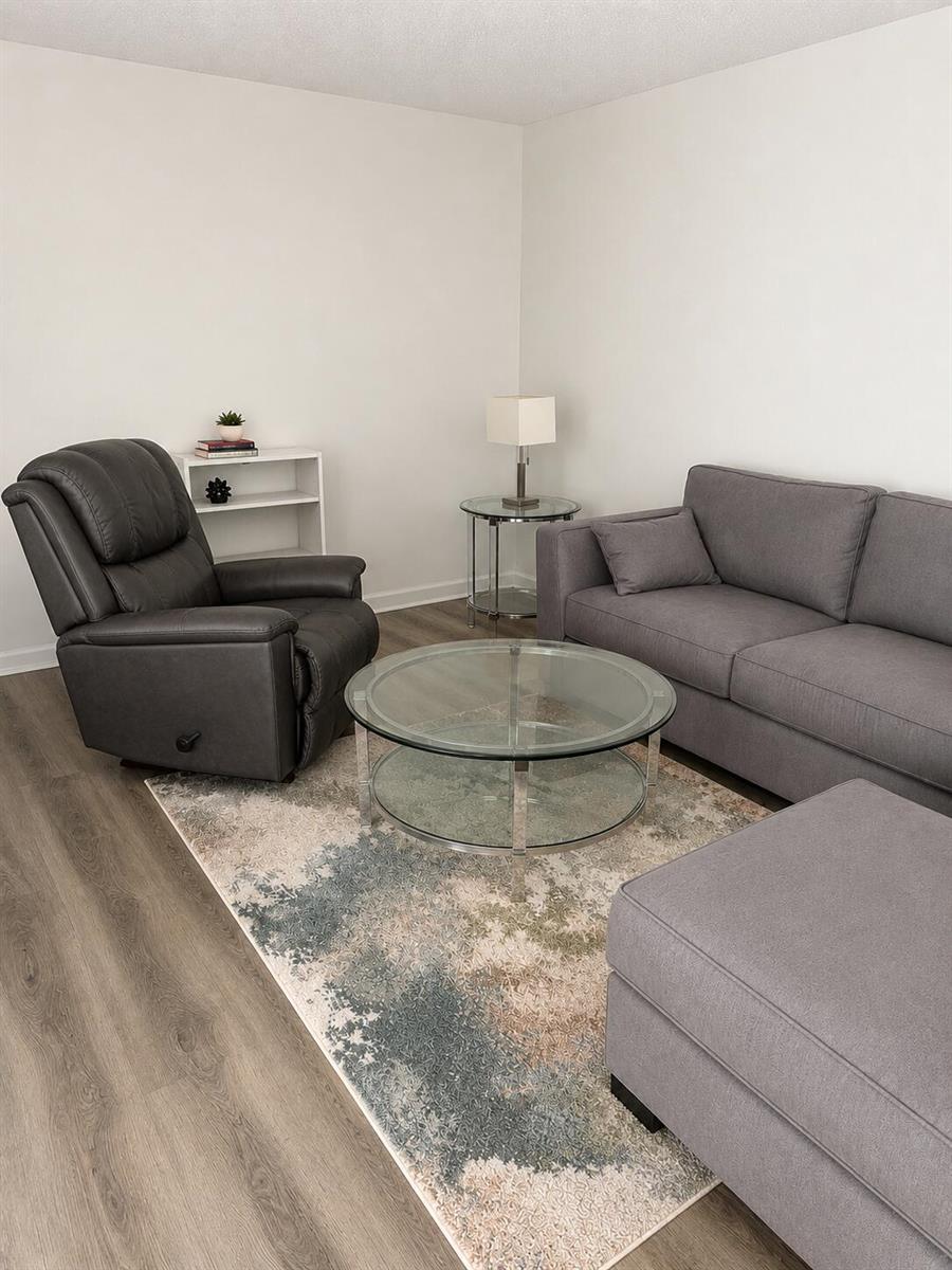 A living room features a gray sofa, a recliner, a glass coffee table, and area rug — 305 Fanshaw H, Boca Raton FL 33434, BOCA RATON, FL