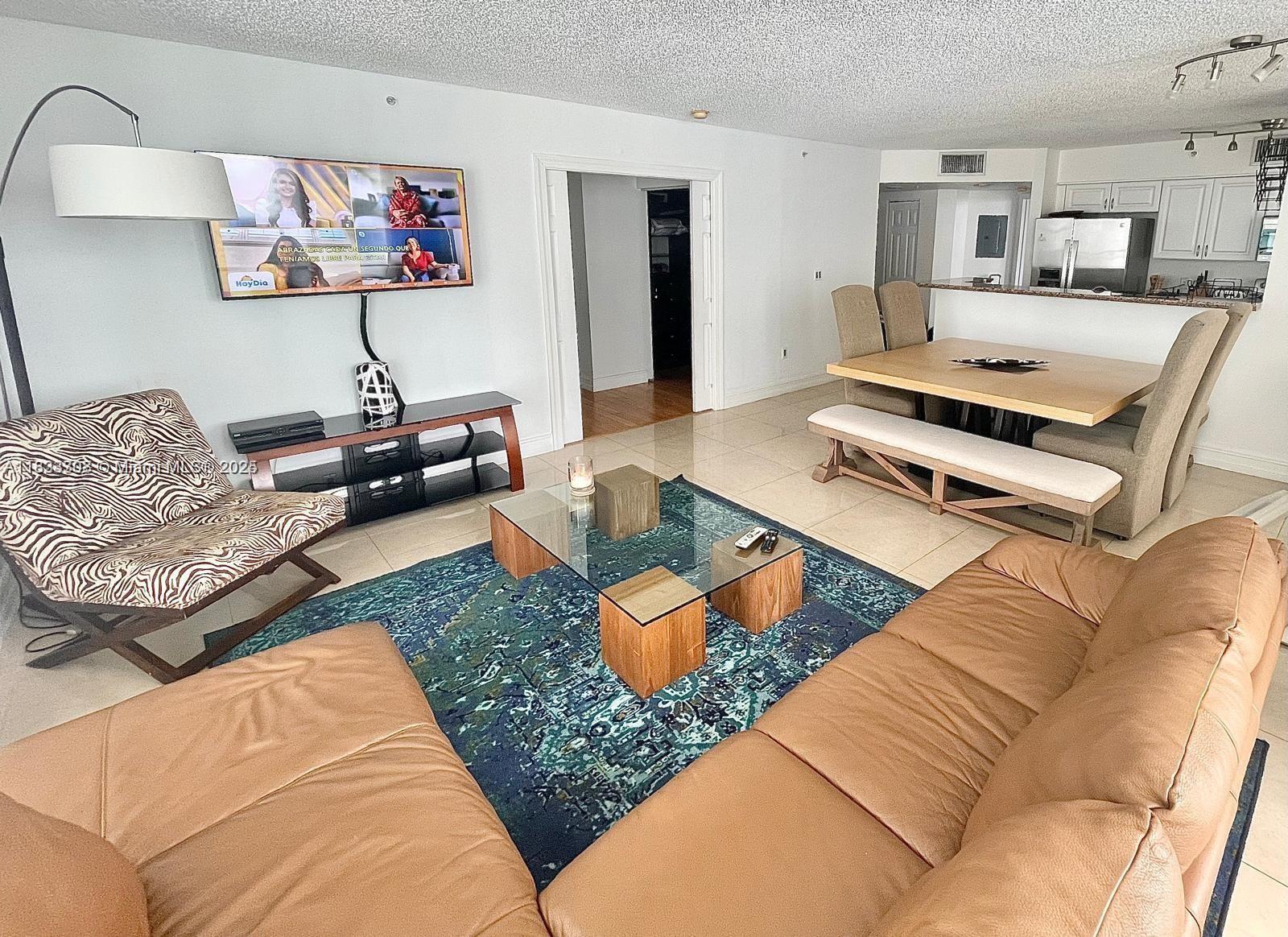 A living room features a leather sofa, zebra-print chair, glass coffee table, and dining area — 1155 Brickell Bay Dr # 1401, Miami FL 33131, MIAMI, FL