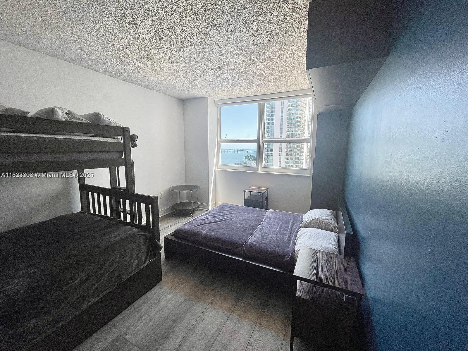 A bedroom features a bunk bed, a platform bed, and a window with water views — 1155 Brickell Bay Dr # 1401, Miami FL 33131, MIAMI, FL