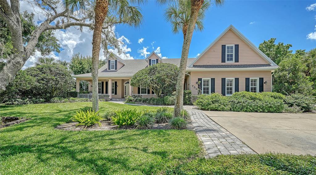 A light-colored house with a gabled roof, dark shutters, and a paved walkway — 756 VANDERBILT DRIVE, NOKOMIS, FL