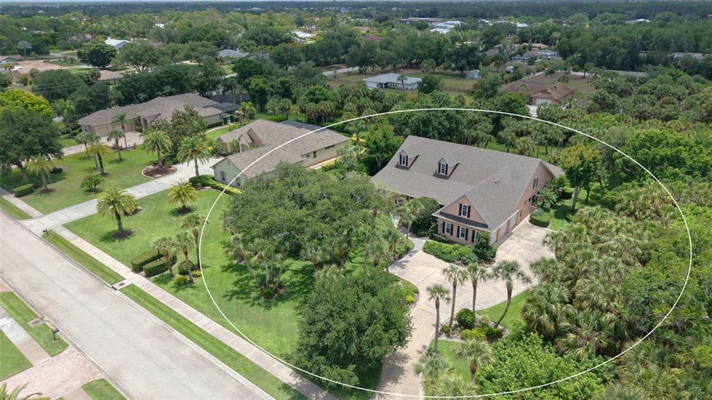 An aerial view shows a large house with a driveway surrounded by trees and landscaping — 756 VANDERBILT DRIVE, NOKOMIS, FL