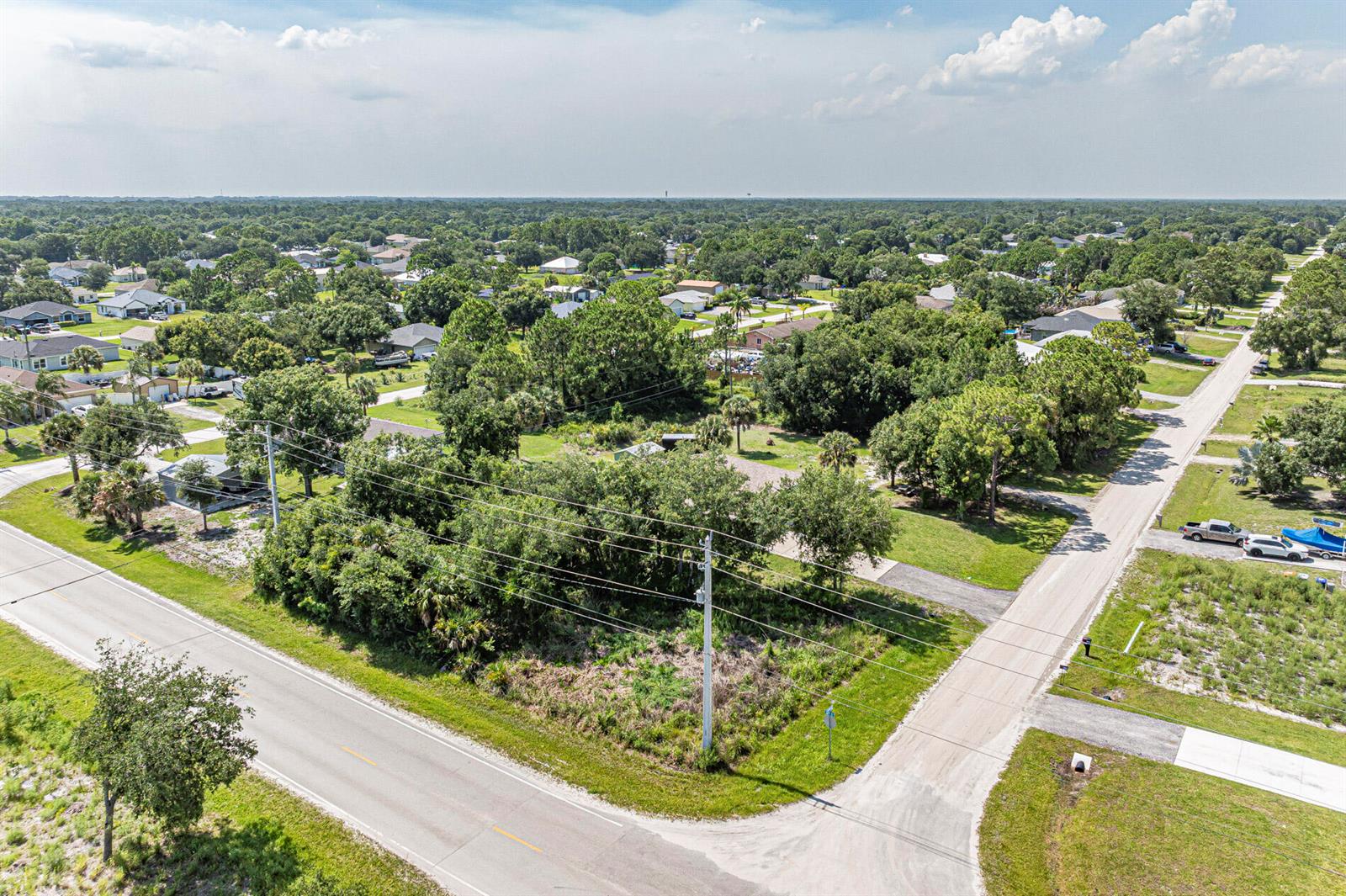 An aerial view shows a wooded corner lot at the intersection of two roads — 8315 102nd Avenue, Vero Beach FL 32967, VERO BEACH, FL