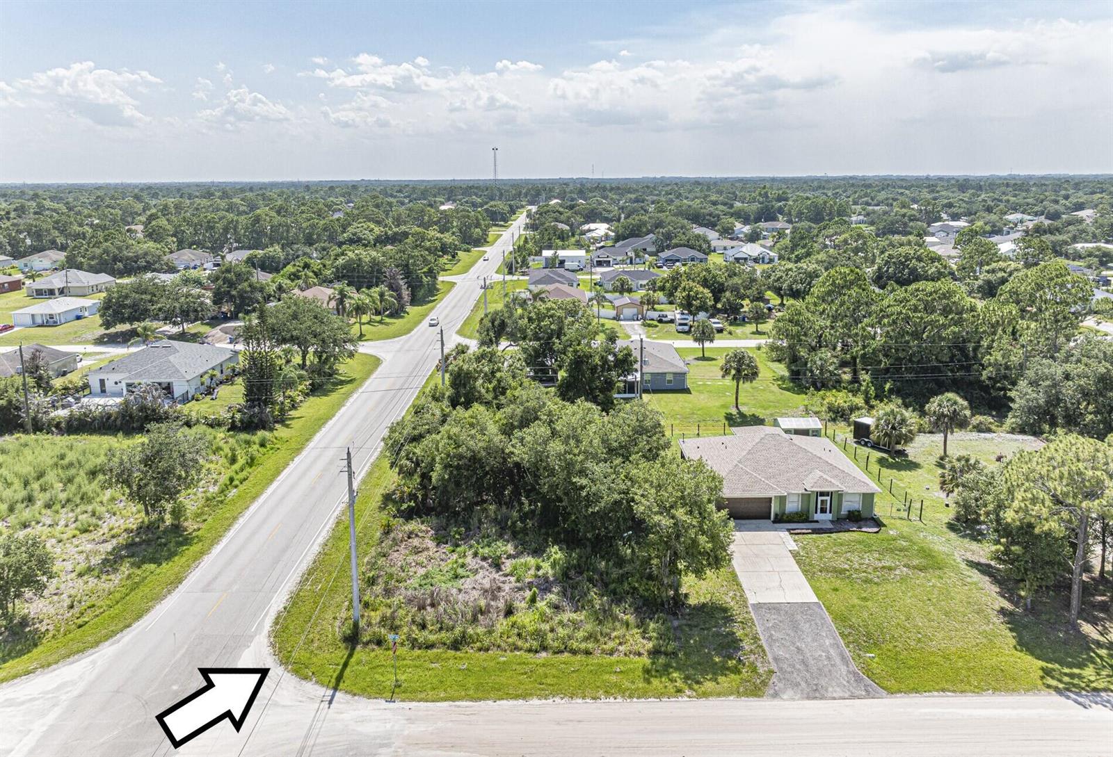 An aerial view shows a vacant lot next to a house along a paved road — 8315 102nd Avenue, Vero Beach FL 32967, VERO BEACH, FL