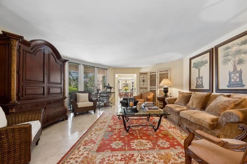 A living room features a large armoire, a patterned area rug, and a beige sofa — 120 SE 5th Avenue # 326, Boca Raton FL 33432, BOCA RATON, FL