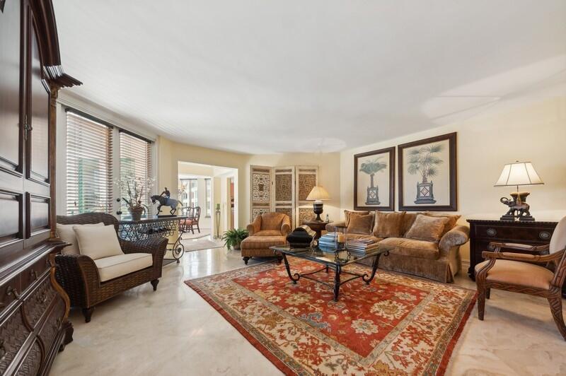 A living room features a red patterned rug, brown furniture, and a large wooden cabinet — 120 SE 5th Avenue # 326, Boca Raton FL 33432, BOCA RATON, FL