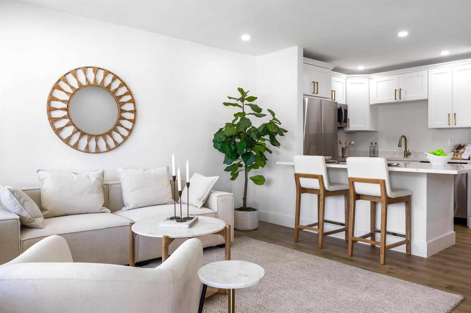 A modern living room and kitchen area with white cabinetry, a sofa, and a plant — 480 Horizons W # 207, Boynton Beach FL 33435, BOYNTON BEACH, FL