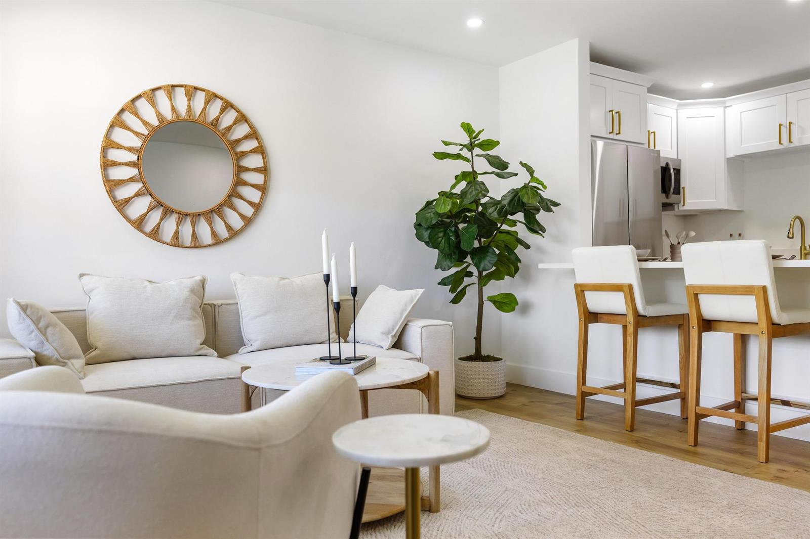 A living room with a sofa, round coffee table, and a plant next to a kitchen — 480 Horizons W # 207, Boynton Beach FL 33435, BOYNTON BEACH, FL