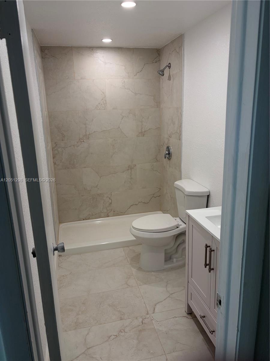 A small bathroom features a tiled shower stall, a toilet, and a white vanity — 6980 NW 186th St # 525A, Hialeah FL 33015, HIALEAH, FL
