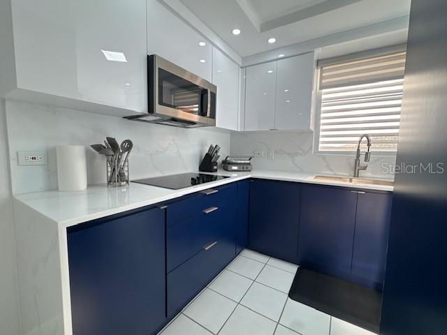 A modern kitchen features navy blue lower cabinets, white upper cabinets, and white marble countertops — A COND VISTA REAL UNIT 10-B, FAJARDO, PR