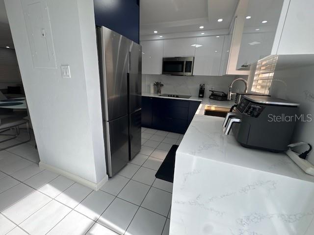 A modern kitchen features white cabinets, a stainless steel refrigerator, and a white marble countertop — A COND VISTA REAL UNIT 10-B, FAJARDO, PR