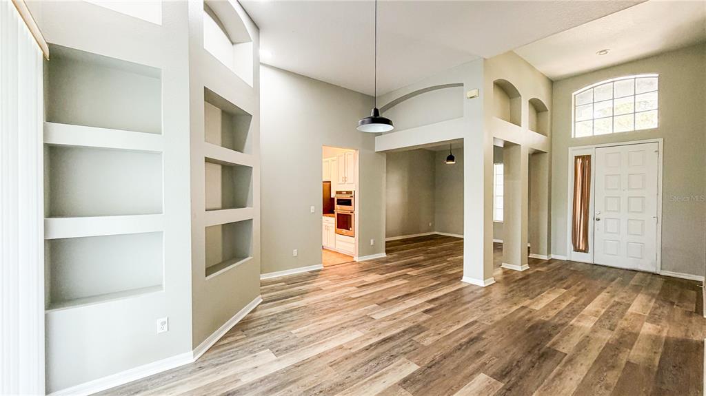 An interior view shows a living area with light gray walls and wood-look flooring — 123 GOLF COURSE PARKWAY, DAVENPORT, FL