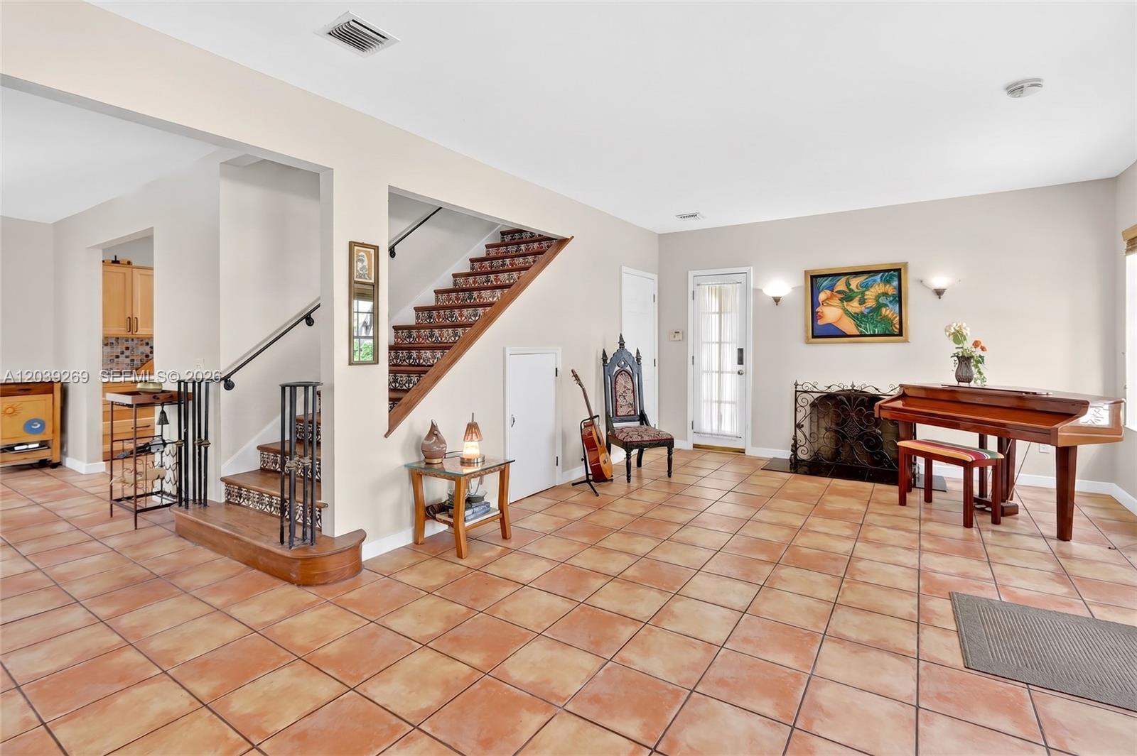 A living room features tiled floors, a staircase with patterned risers, and a grand piano — 1642 SW 12th St, Miami FL 33135, MIAMI, FL