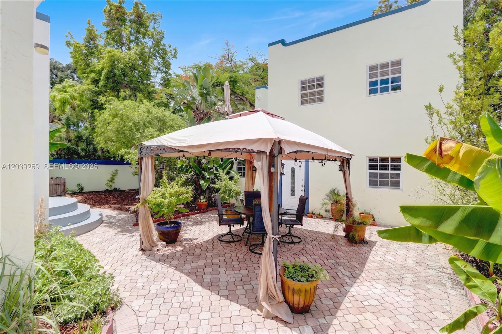 A paved patio features a gazebo with outdoor seating set against a two-story building — 1642 SW 12th St, Miami FL 33135, MIAMI, FL