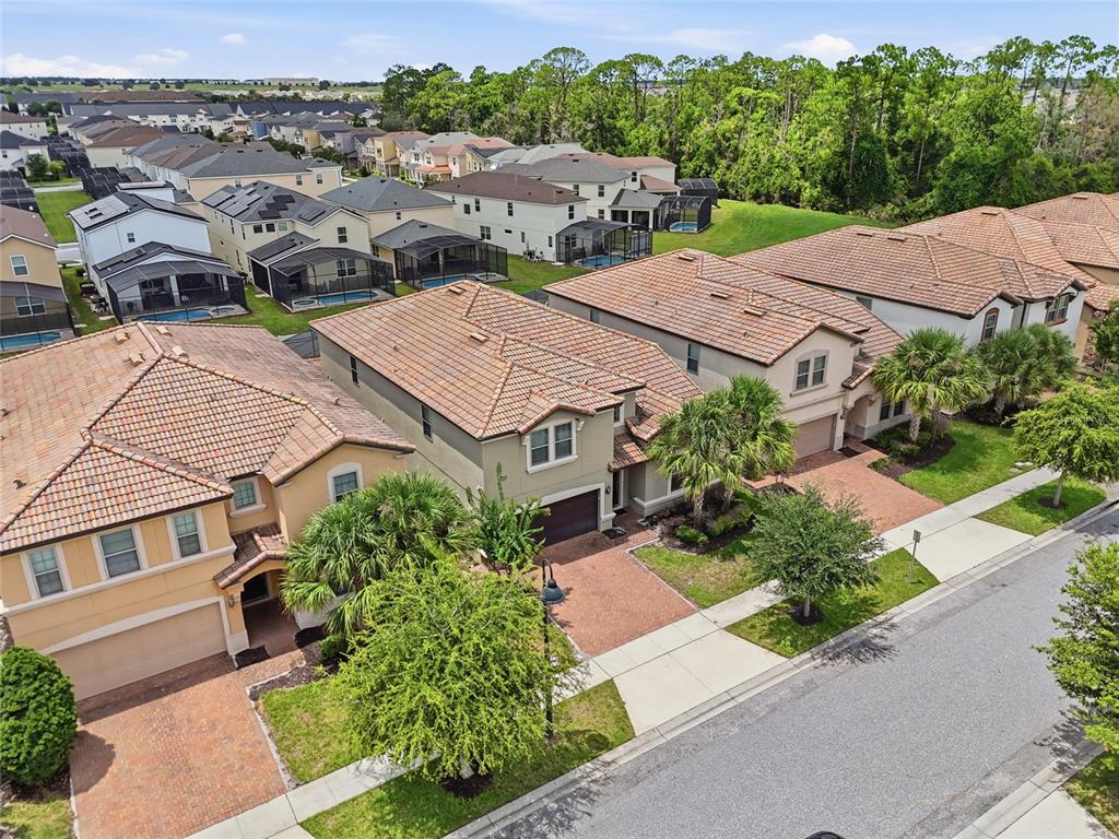 An aerial view shows several suburban houses with tiled roofs and brick driveways — 1610 LIMA AVENUE, KISSIMMEE, FL