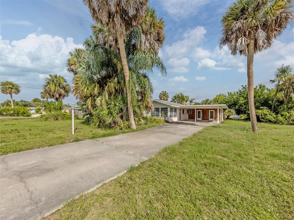A single-story house with a concrete driveway and palm trees under a blue sky — 730 S VENICE BOULEVARD, VENICE, FL