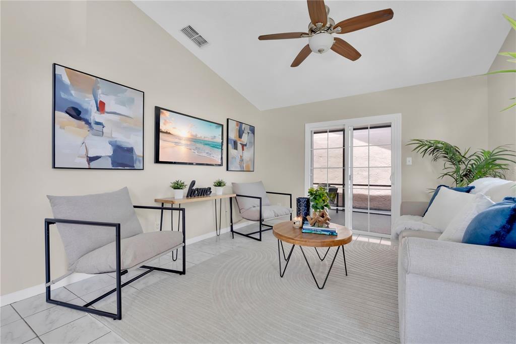 A living room features a vaulted ceiling, a ceiling fan, two armchairs, and a sofa — 272 SAN GABRIEL STREET, WINTER SPRINGS, FL