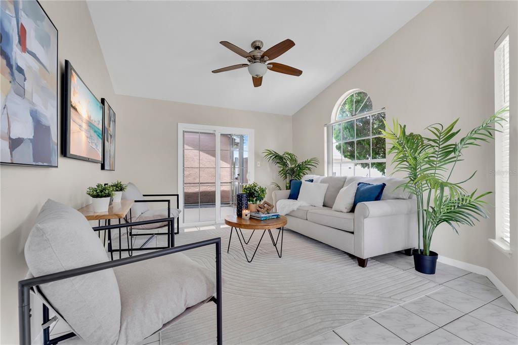 A bright living room features a light-colored sofa, two armchairs, a coffee table, and tile flooring — 272 SAN GABRIEL STREET, WINTER SPRINGS, FL