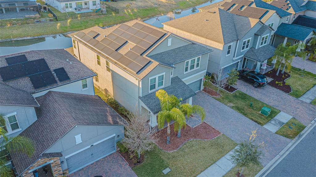 An aerial view shows a two-story suburban house with solar panels on the roof — 6244 ENGLISH HOLLOW ROAD, TAMPA, FL