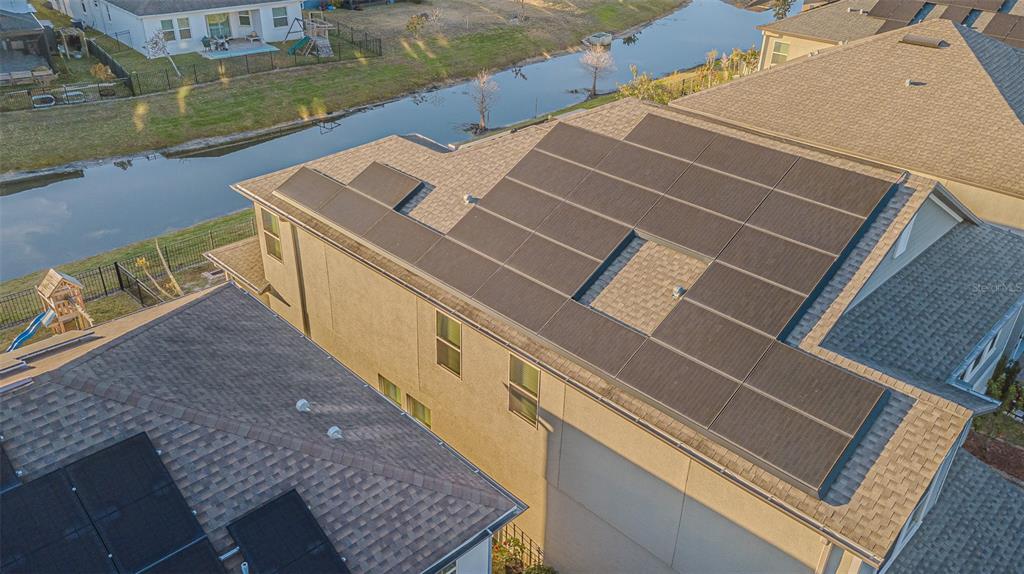 An aerial view shows a residential roof with solar panels installed on two adjacent homes — 6244 ENGLISH HOLLOW ROAD, TAMPA, FL
