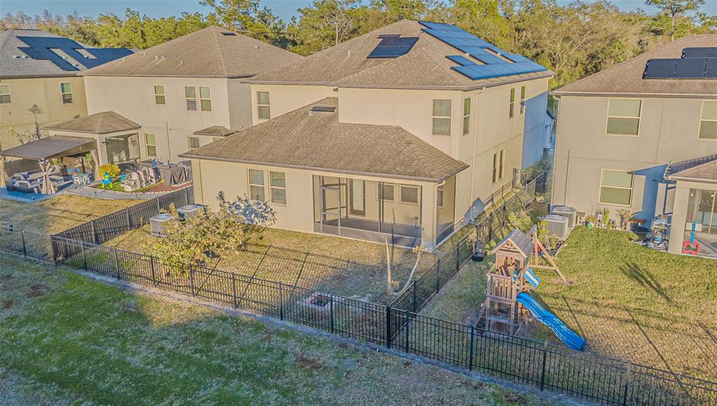 An aerial view of a two-story house with solar panels and a fenced backyard — 6244 ENGLISH HOLLOW ROAD, TAMPA, FL