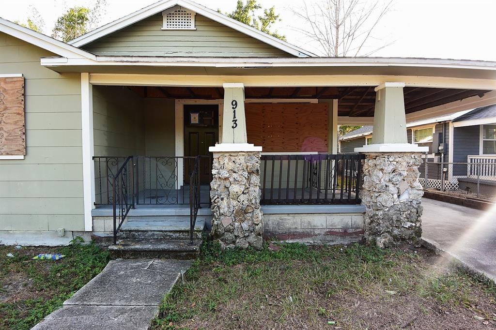 A single-story house features a front porch with stone pillars and boarded-up windows — 913 E 28TH AVENUE, TAMPA, FL