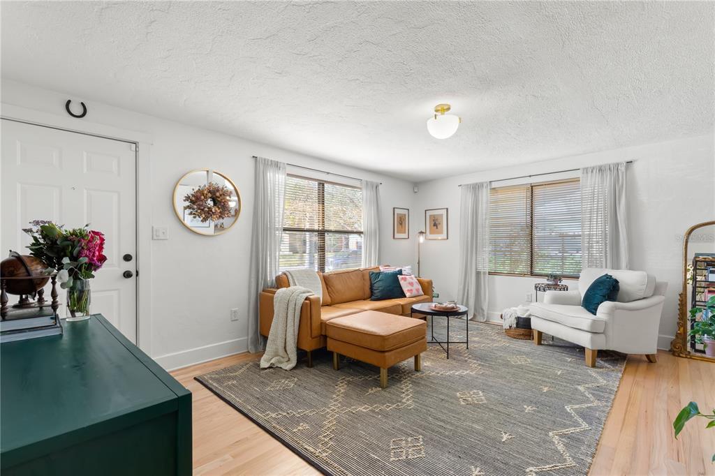 A living room features a leather sectional, a white armchair, and a large patterned rug — 837 42ND AVENUE N, ST PETERSBURG, FL