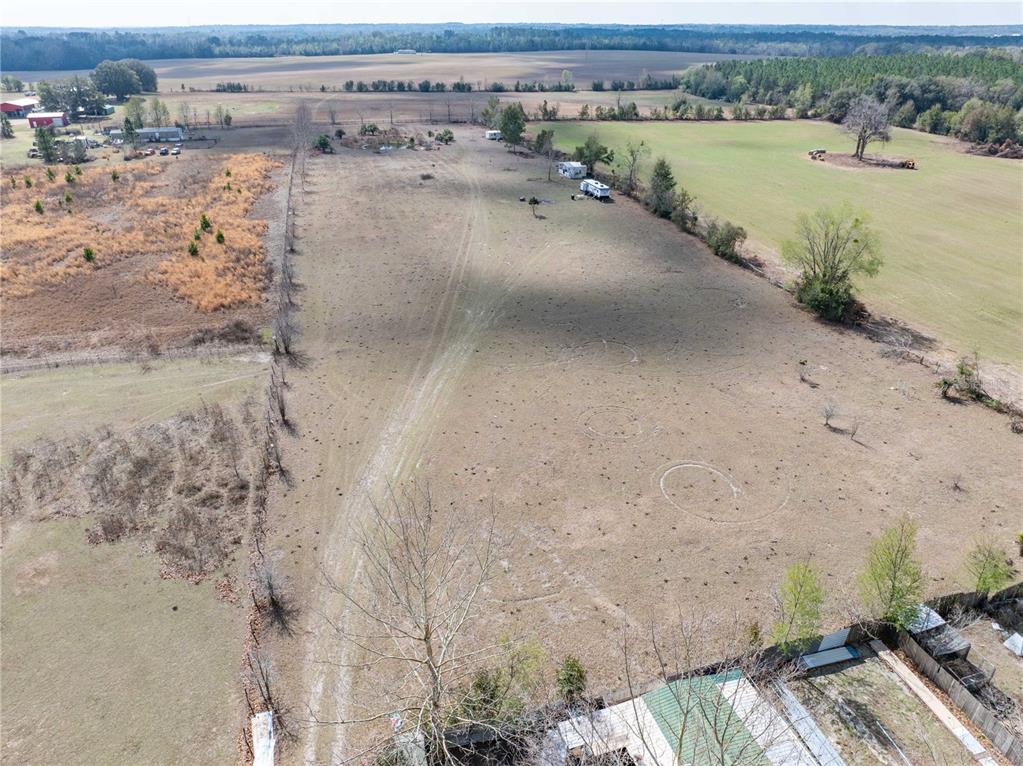 An aerial view shows a large, open field with several parked campers and distant trees — 3378 W STATE ROAD 238, LAKE BUTLER, FL