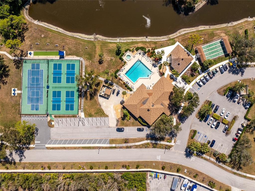 Aerial view of a community recreation area featuring a pool, tennis courts, and parking lot — 413 TOMOKA DRIVE, ENGLEWOOD, FL