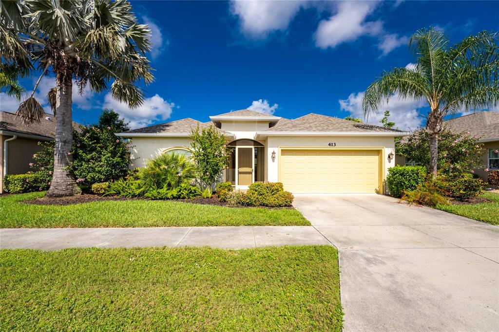 A single-story house with a yellow garage door, a front porch, and palm trees — 413 TOMOKA DRIVE, ENGLEWOOD, FL