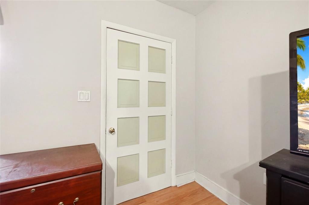A white eight-panel door is set in a room with light walls and wood flooring — 2616 HACIENDA DRIVE, LORIDA, FL