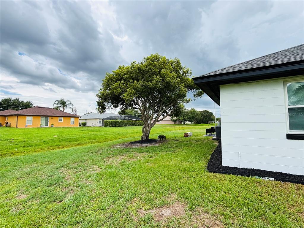 A screened-in porch with a gray speckled floor, white walls, and black trim — 504 BLACKBIRD LANE, POINCIANA, FL