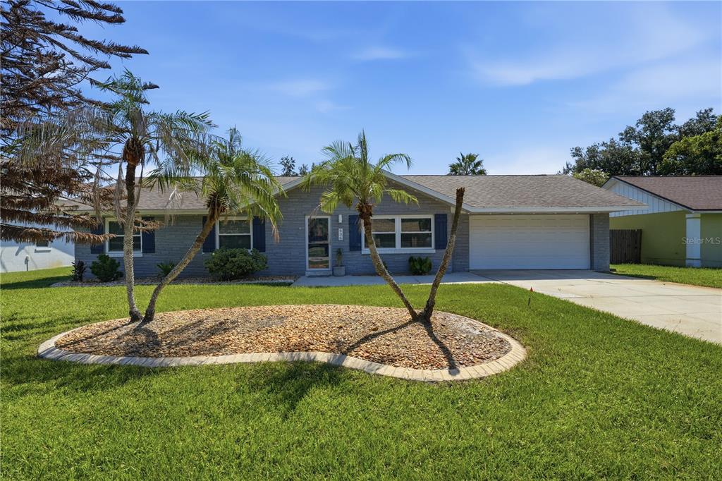 A single-story gray brick house features a two-car garage and a landscaped front yard — 636 DEVON STREET, PORT ORANGE, FL
