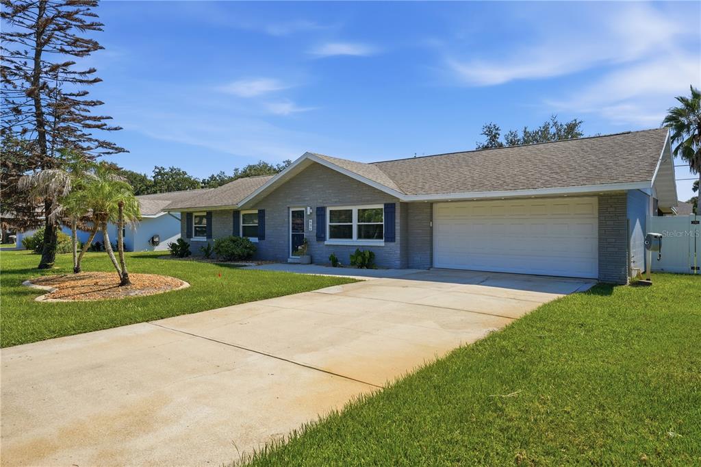 A single-story gray brick house features a two-car garage and a concrete driveway — 636 DEVON STREET, PORT ORANGE, FL