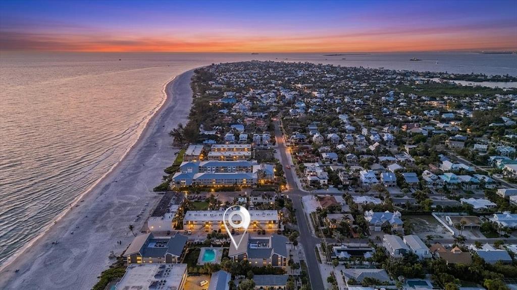 An aerial view of a coastal neighborhood with a beach, ocean, and sunset sky — 6804 GULF DRIVE UNIT 6804, HOLMES BEACH, FL