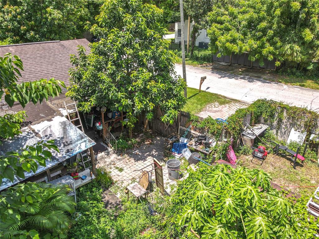 An aerial view shows a backyard with a paved patio, trees, and various outdoor items — 1906 VINE STREET, ORLANDO, FL