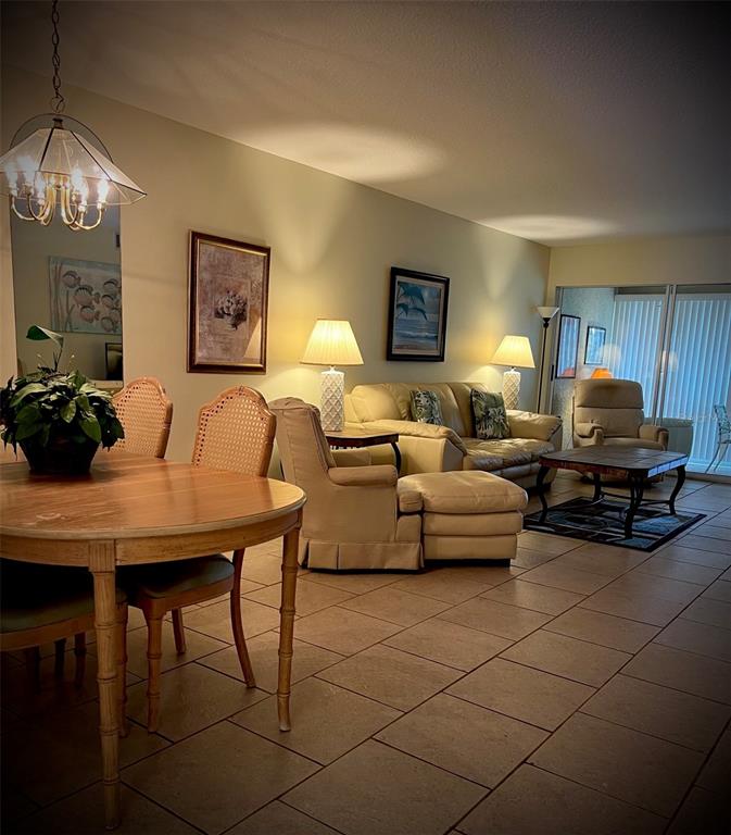 A dining area and living room with tile flooring, neutral walls, and traditional furniture — 4499 LONGMEADOW UNIT 79, SARASOTA, FL