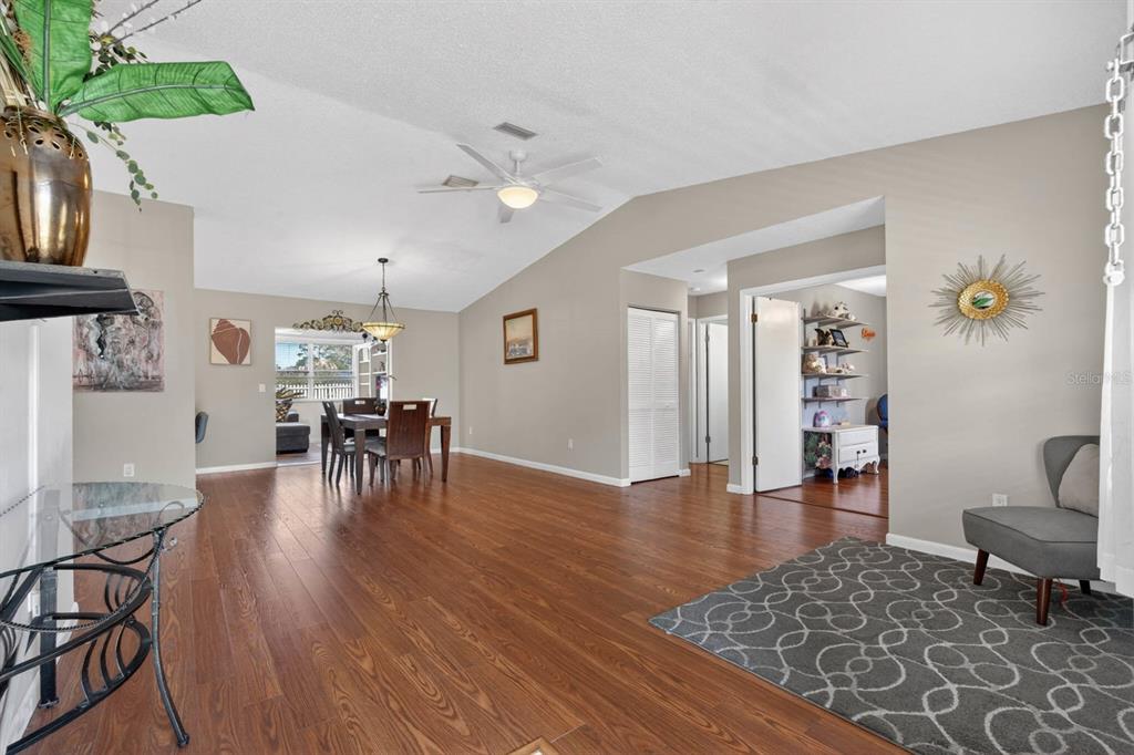 A living and dining area features wood-look flooring, a vaulted ceiling, and a ceiling fan — 46 WOOD CEDAR DRIVE, PALM COAST, FL